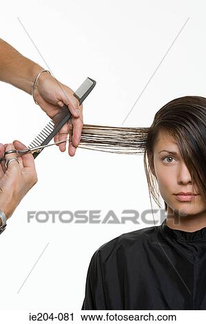 Stock Image - A woman having her hair cut. Fotosearch