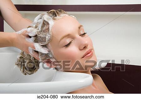 Stock Image - A woman having her hair washed. Fotosearch