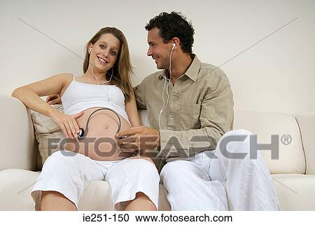 A womans bump listening to music View Large Photo Image Stock Image - A womans bump listening to music. Fotosearch