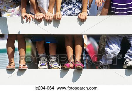 Picture - Children leaning against a fence. Fotosearch