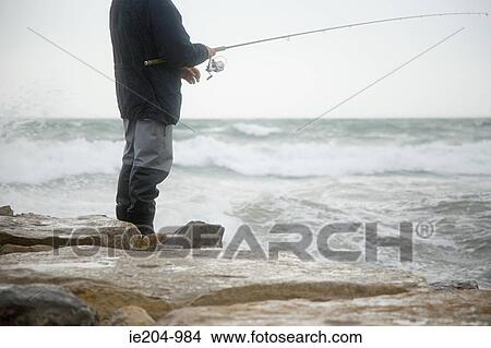 Fisherman fishing in stormy sea View Large Photo Image Picture - Fisherman fishing in stormy sea. Fotosearch