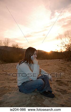 Girl on cellphone outdoors View Large Photo Image Stock Photograph - Girl on cellphone outdoors. Fotosearch