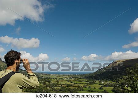 Man looking at glenariff with binoculars View Large Photo Image Stock Photo - Man looking at glenariff with binoculars. Fotosearch