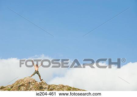 Man on top of rocks View Large Photo Image Stock Image - Man on top of rocks. Fotosearch