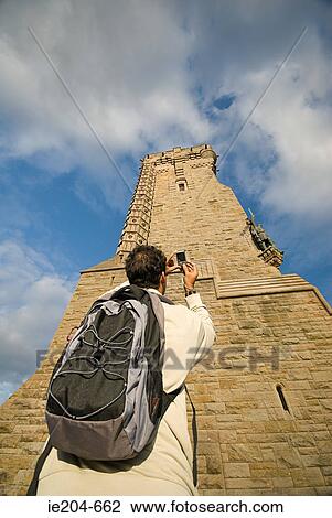Stock Image - Man photographing wallace monument. Fotosearch