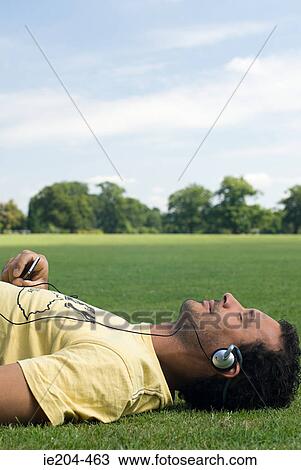 Man wearing headphones and lying down View Large Photo Image Stock Image - Man wearing headphones and lying down. Fotosearch