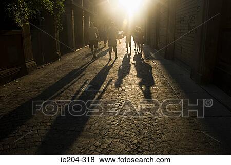 Stock Photo - Rear view of people walking down a street. Fotosearch