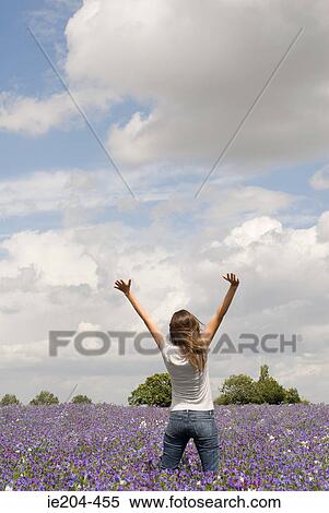 Stock Photography - Woman in a field of flowers. Fotosearch