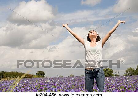 Stock Photograph - Woman in field on flowers. Fotosearch