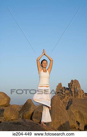 Woman in yoga pose by rocks View Large Photo Image Stock Photo - Woman in yoga pose by rocks. Fotosearch