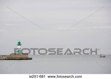 Lighthouse and boat on sea View Large Photo Image Stock Image - Lighthouse and boat on sea. Fotosearch