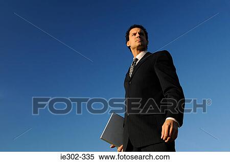 Stock Photography - Businessman against blue sky. Fotosearch