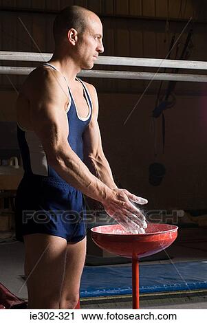 Gymnast putting chalk on his hands View Large Photo Image Stock Image - Gymnast putting chalk on his hands. Fotosearch