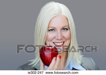 Stock Photo - Woman holding an apple. Fotosearch
