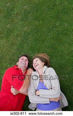 A couple lying on grass View Large Photo Image Stock Image - A couple lying on grass. Fotosearch