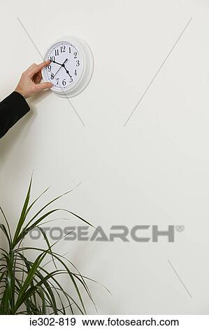 An office worker adjusting the hands on a clock View Large Photo Image Stock Photo - An office worker adjusting the hands on a clock. Fotosearch