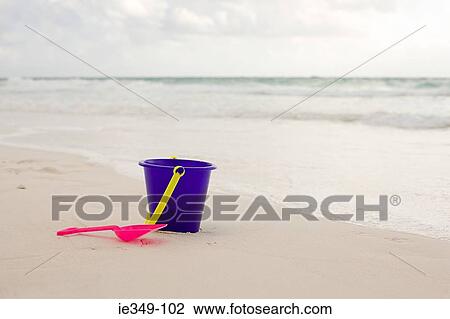 Bucket and spade on a beach View Large Photo Image Stock Image - Bucket and spade on a beach. Fotosearch