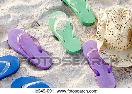 Flip flops and a sun hat on a beach View Large Photo Image Stock Image - Flip flops and a sun hat on a beach. Fotosearch