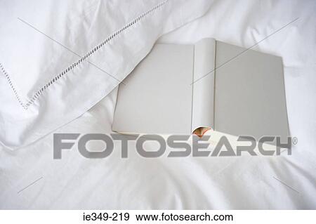 Stock Photo - Book on a bed. Fotosearch