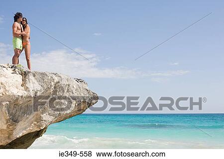Couple on rock by the sea View Large Photo Image Stock Photo - Couple on rock by the sea. Fotosearch
