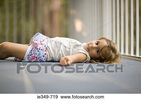 Girl lying on floor View Large Photo Image Stock Photo - Girl lying on floor. Fotosearch