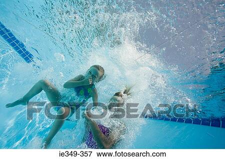 Stock Photo - Girls jumping in swimming pool. Fotosearch