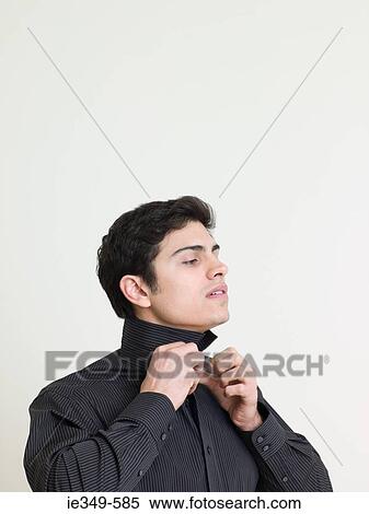 Stock Photography - Man buttoning shirt. Fotosearch