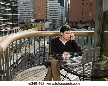Man on balcony with laptop View Large Photo Image Stock Image - Man on balcony with laptop. Fotosearch
