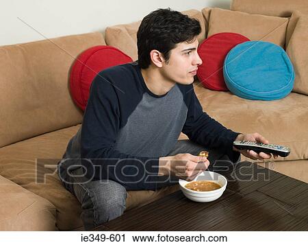 Man with food watching television View Large Photo Image Stock Image - Man with food watching television. Fotosearch