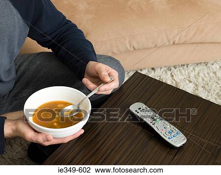 Man with soup and remote control View Large Photo Image Stock Image - Man with soup and remote control. Fotosearch