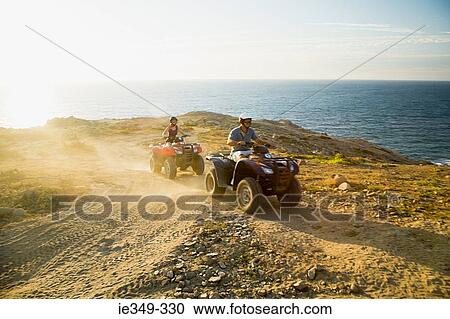Stock Image - People riding all terrain vehicles. Fotosearch