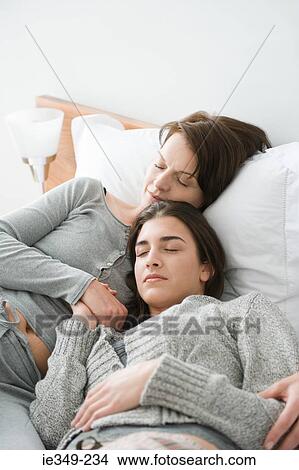 Two women sleeping on bed View Large Photo Image Picture - Two women sleeping on bed. Fotosearch