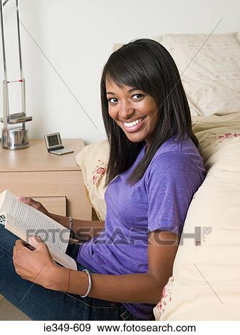 Stock Photo - Woman in bedroom with book. Fotosearch