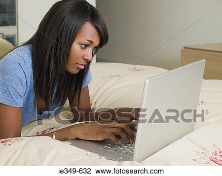 Woman on bed with laptop View Large Photo Image Stock Image - Woman on bed with laptop. Fotosearch