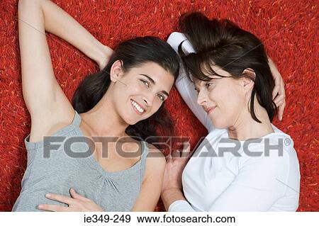 Women lying on rug View Large Photo Image Stock Photo - Women lying on rug. Fotosearch