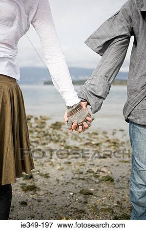 Young couple holding hands View Large Photo Image Stock Photo - Young couple holding hands. Fotosearch