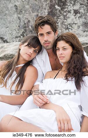 Young man and two young women View Large Photo Image Stock Photograph - Young man and two young women. Fotosearch