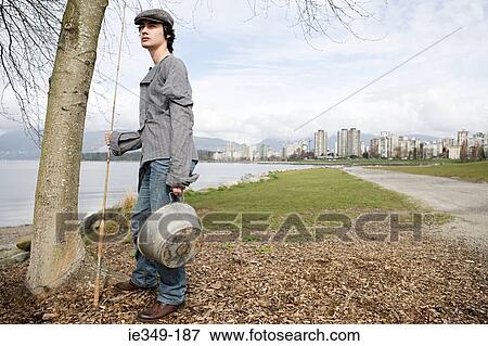 Young man with fishing rod View Large Photo Image Stock Photo - Young man with fishing rod. Fotosearch