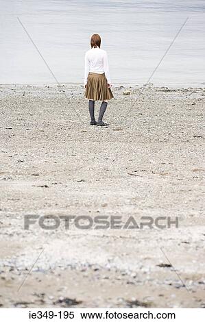 Stock Photography - Young woman looking at sea. Fotosearch