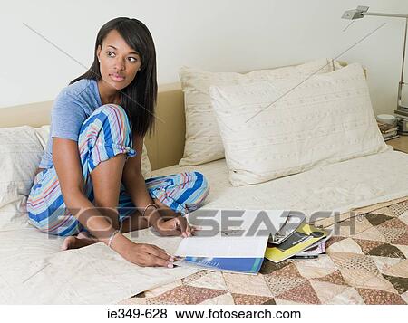 Young woman on bed with magazines View Large Photo Image Stock Photo - Young woman on bed with magazines. Fotosearch