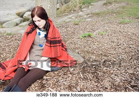 Young woman sitting alone View Large Photo Image Stock Photo - Young woman sitting alone. Fotosearch