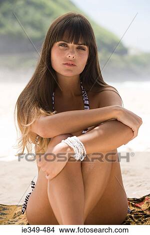 Young woman sitting on beach View Large Photo Image Picture - Young woman sitting on beach. Fotosearch