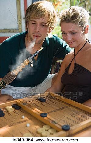Picture - Couple with hookah and backgammon. Fotosearch