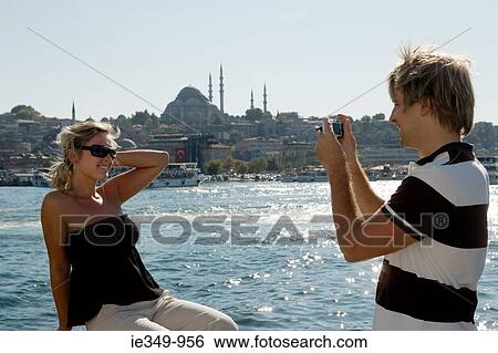Man photographing girlfriend View Large Photo Image Stock Photograph - Man photographing girlfriend. Fotosearch