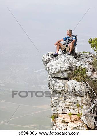 Man sitting on a rock View Large Photo Image Stock Photography - Man sitting on a rock. Fotosearch