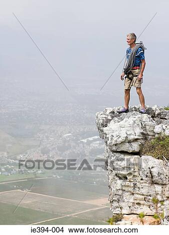 Man standing on a rock View Large Photo Image Picture - Man standing on a rock. Fotosearch
