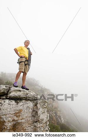 Man standing on a rock View Large Photo Image Stock Image - Man standing on a rock. Fotosearch
