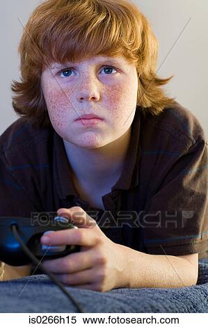 A boy playing a video game View Large Photo Image Stock Photography - A boy playing a video game. Fotosearch