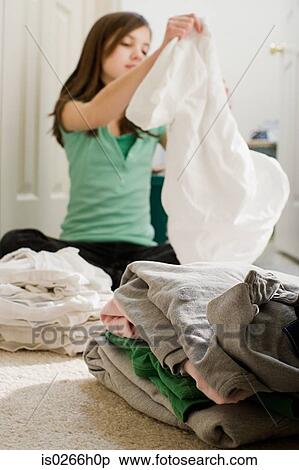 Stock Photography - A girl arranging laundry into piles. Fotosearch