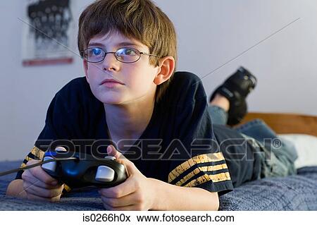 Boy playing a video game View Large Photo Image Stock Photo - Boy playing a video game. Fotosearch